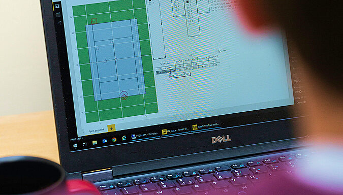 Laptop screen showing sports-venue planning software with a court diagram, representing data-driven sports analysis.