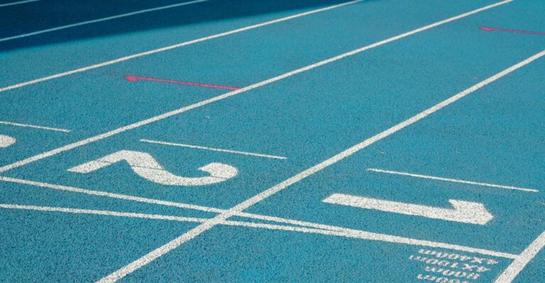 Close-up of the numbered starting lanes on a blue athletics running track.